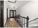 Hallway with wood floors leads to a balcony with black metal railings and dark wood trim at 552 Blue Rock Dr, Charlotte, NC 28213