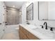Bathroom featuring a double vanity, modern fixtures, and a bathtub with a shower at 554 W Cama St, Charlotte, NC 28217