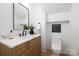 Modern half-bathroom with elegant marble countertops, a dark faucet, and minimalist decor, offering a sleek and stylish design at 554 W Cama St, Charlotte, NC 28217