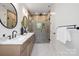 Modern bathroom featuring a double vanity, glass enclosed shower, and sleek fixtures at 554 W Cama St, Charlotte, NC 28217
