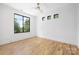 Bright bedroom with hardwood floors, ceiling fan, and a view of the outdoor scenery through a large window at 554 W Cama St, Charlotte, NC 28217