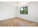Well-lit bedroom with hardwood floors and a large window offering a view of the outdoors at 554 W Cama St, Charlotte, NC 28217