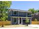Two-story home featuring a modern design, dark gray siding, black trim windows, and a sleek, dark-colored garage door at 554 W Cama St, Charlotte, NC 28217