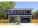 New construction two-story home featuring a modern design, black trim windows, and a sleek, dark-colored garage door at 554 W Cama St, Charlotte, NC 28217