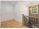 Bright hallway featuring a wooden staircase, modern light fixture and window with backyard view at 554 W Cama St, Charlotte, NC 28217