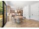 Modern kitchen and dining area with light wood cabinets, stainless steel appliances, and a view to the outdoors at 554 W Cama St, Charlotte, NC 28217