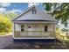 Charming home featuring a welcoming front porch with wood railing and a light-colored exterior under a clear blue sky at 555 Pryor St, Chester, SC 29706