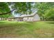 Spacious backyard with a garden, screened porch, and ample green space at 604 Chaney Rd, Monroe, NC 28110