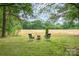Serene backyard setting with chairs, a fire pit, and scenic views of the open field at 604 Chaney Rd, Monroe, NC 28110