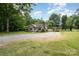 Charming single-story home with a well-maintained lawn, a carport, and a gravel driveway at 604 Chaney Rd, Monroe, NC 28110