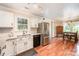 Bright kitchen featuring white cabinets, stainless steel appliances, and hardwood floors that lead to dining area at 604 Chaney Rd, Monroe, NC 28110