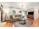 Bright living room boasts a fireplace, modern lighting, an exterior door, and lovely hardwood flooring at 604 Chaney Rd, Monroe, NC 28110