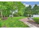 Well-maintained backyard featuring a brick patio, seating area, lush greenery, and a storage shed at 611 Heathermoor Ct, Charlotte, NC 28209