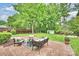 Serene backyard with brick patio seating area, a lush lawn, a storage shed and mature trees at 611 Heathermoor Ct, Charlotte, NC 28209