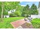 Serene backyard with brick patio, lush lawn, mature trees, and cozy outdoor seating area at 611 Heathermoor Ct, Charlotte, NC 28209