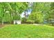 Expansive backyard with a lush green lawn, garden, a storage shed, and mature trees at 611 Heathermoor Ct, Charlotte, NC 28209