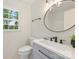 Stylish bathroom featuring modern fixtures, a round mirror, and a decorative plant at 611 Heathermoor Ct, Charlotte, NC 28209