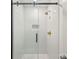 Modern walk-in shower featuring glass doors, white subway tile, and gold fixtures at 611 Heathermoor Ct, Charlotte, NC 28209