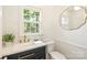 A stylish powder room featuring a modern vanity, white countertop, elegant gold fixtures, and decorative mirror at 611 Heathermoor Ct, Charlotte, NC 28209