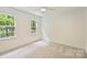 Bedroom featuring natural light from two windows, neutral carpet, and ample open space at 611 Heathermoor Ct, Charlotte, NC 28209