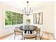 Bright dining area featuring a modern chandelier, round table, and a large window with scenic views at 611 Heathermoor Ct, Charlotte, NC 28209