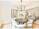Dining area showcasing a modern light fixture, artwork, and seamless flow into the living room at 611 Heathermoor Ct, Charlotte, NC 28209