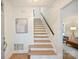 Bright foyer featuring wood stairs with white risers and access to the living area at 611 Heathermoor Ct, Charlotte, NC 28209