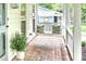 Cozy front porch with brick flooring, a hanging swing, and comfortable decorative pillows at 611 Heathermoor Ct, Charlotte, NC 28209
