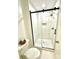 Modern bathroom shower with glass door, a rainfall shower head, tile floors, and built-in niche at 611 Heathermoor Ct, Charlotte, NC 28209