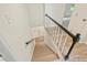 View of staircase with light wood steps and black and white railings at 611 Heathermoor Ct, Charlotte, NC 28209