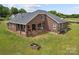 Aerial view of a brick home with a covered back porch and expansive green yard, perfect for outdoor activities at 6218 Indian Trail Fairview Rd, Indian Trail, NC 28079
