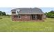 Brick home featuring a back porch perfect for relaxing, complemented by an expansive yard and green grass at 6218 Indian Trail Fairview Rd, Indian Trail, NC 28079