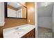 Bathroom featuring a white sink on a wooden vanity, a large framed mirror, and views to another room at 6218 Indian Trail Fairview Rd, Indian Trail, NC 28079