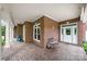 Inviting covered porch with brick floors, white columns, and comfortable seating area at the entrance at 6218 Indian Trail Fairview Rd, Indian Trail, NC 28079