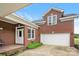 Exterior view of a brick home with a two-car garage and landscaped garden beds at the entry at 6218 Indian Trail Fairview Rd, Indian Trail, NC 28079