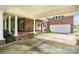 Facade of the brick home with a covered porch, white garage door, pillars, and manicured landscaping at 6218 Indian Trail Fairview Rd, Indian Trail, NC 28079