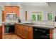 A kitchen with dark wood cabinets, stainless steel appliances, and gray countertops at 6218 Indian Trail Fairview Rd, Indian Trail, NC 28079