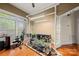 An office area with a plant-growing setup, large windows, and hardwood flooring at 6218 Indian Trail Fairview Rd, Indian Trail, NC 28079
