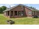 Brick home featuring a cozy back porch, spacious yard, and a brick fire pit, perfect for outdoor gatherings at 6218 Indian Trail Fairview Rd, Indian Trail, NC 28079