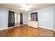 Bedroom with hardwood floors, ceiling fan, dresser, and two windows with dark curtains at 625 2Nd Ne St, Hickory, NC 28601