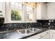 This kitchen sink features an undermount stainless steel sink, black marble countertop, and double hung window at 625 2Nd Ne St, Hickory, NC 28601
