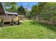 Lush green backyard with a wooden deck, pergola, privacy fence, and mature trees at 7221 Leaves Ln, Charlotte, NC 28213