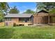Expansive backyard featuring a wooden deck, pergola, well-manicured lawn, and partial privacy fence at 7221 Leaves Ln, Charlotte, NC 28213