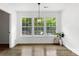 Cozy dining room filled with natural light, featuring light wood floors and a modern chandelier at 7221 Leaves Ln, Charlotte, NC 28213