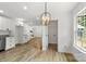 Bright dining area with light wood floors, a modern light fixture, and large windows at 7221 Leaves Ln, Charlotte, NC 28213
