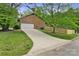 Spacious driveway leading to a two-car garage, complemented by a well-maintained lawn and wooden fence at 7221 Leaves Ln, Charlotte, NC 28213