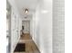 Bright hallway with light wood floors, stylish lighting, and a freshly painted white brick wall at 7221 Leaves Ln, Charlotte, NC 28213