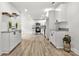 Modern kitchen with white cabinets, stainless steel appliances, and light wood floors at 7221 Leaves Ln, Charlotte, NC 28213
