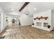 Open-concept living room featuring light wood floors, a brick fireplace, and views of the kitchen at 7221 Leaves Ln, Charlotte, NC 28213