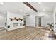 Spacious living room with light wood floors, vaulted ceiling, and a white painted brick fireplace at 7221 Leaves Ln, Charlotte, NC 28213